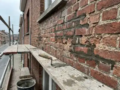 Bakstenen gevel waarvan de voegen gedeeltelijk vernieuwd zijn